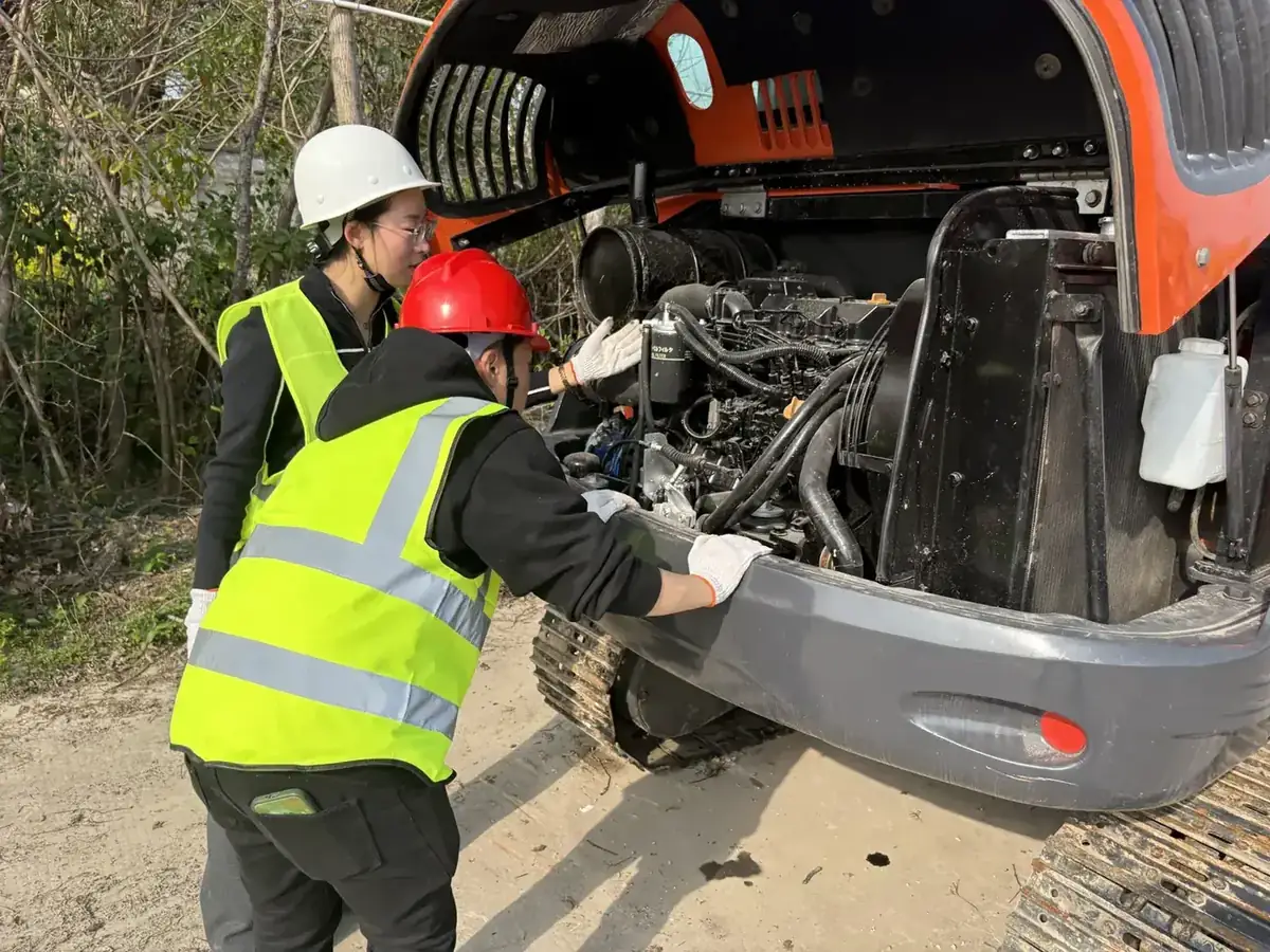 Inspecting the engine bay of a used excavator